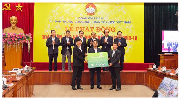 Đại diện Vietcombank (bên phải) ủng hộ 10 tỷ đồng tại lễ phát động toàn dân ủng hộ phòng, chống Covid-19.